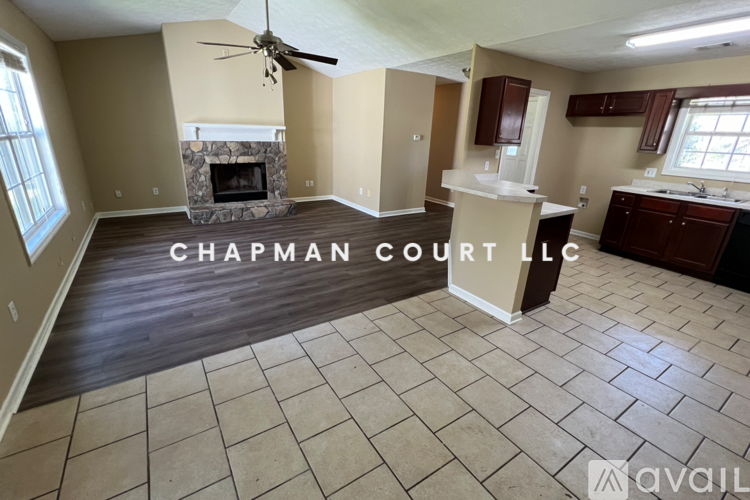 A spacious room with a fireplace and a ceiling fan.