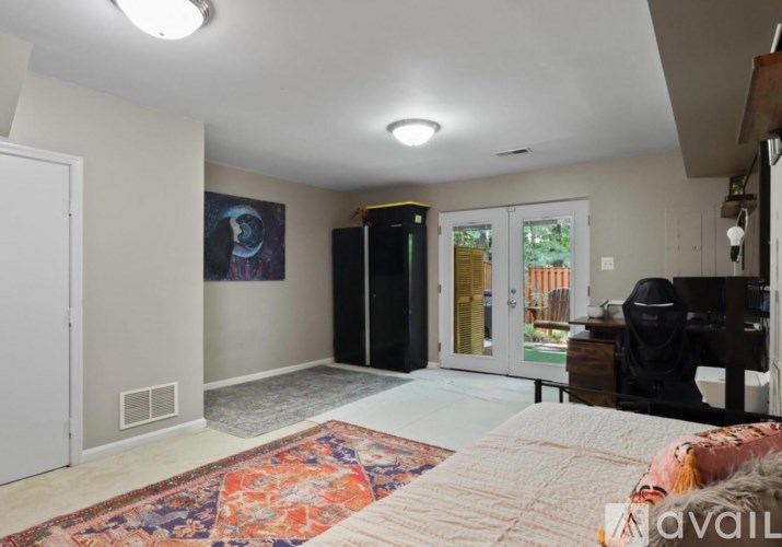 A room with a rug on the floor and a painting on the wall.