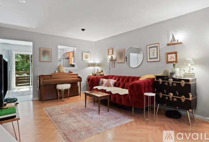 A living room with a red couch and a piano.