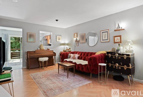 A living room with a red couch and a piano.