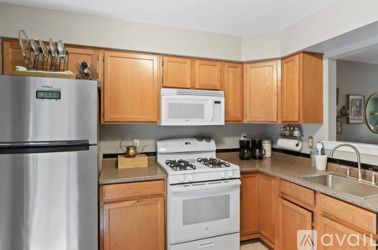 A kitchen with wooden cabinets and a stainless steel refrigerator.