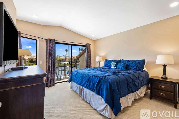 A bedroom with a large bed and a flat screen TV.