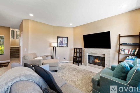 A living room with a fireplace and a television on the wall.