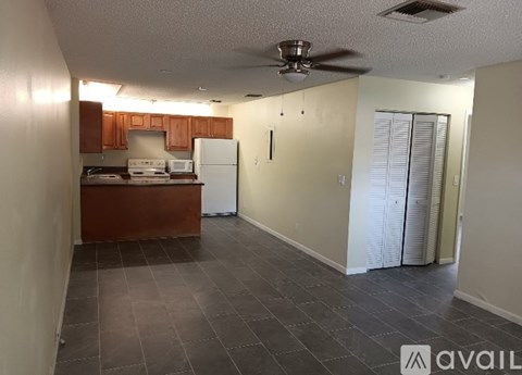 A kitchen with a refrigerator, microwave, and oven.