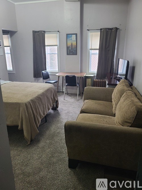 A bedroom with a bed, couch, and television.