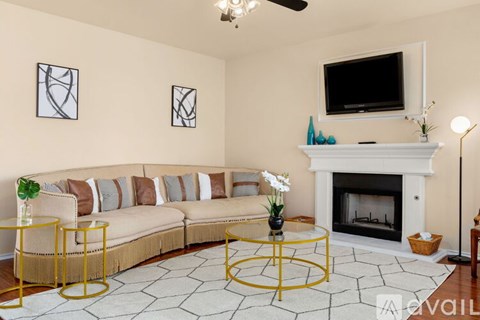 A living room with a white fireplace and a television above it.