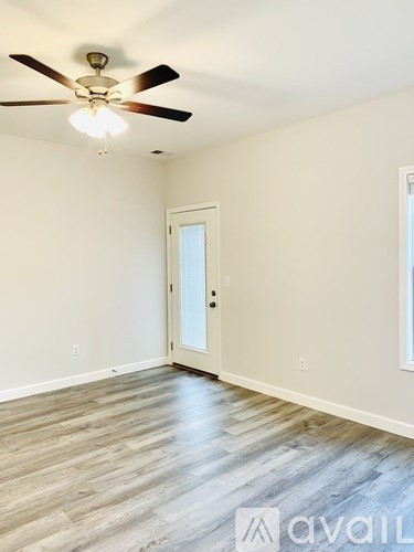 A room with a ceiling fan and a door.
