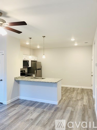 A kitchen area with a counter and a fan on the ceiling.