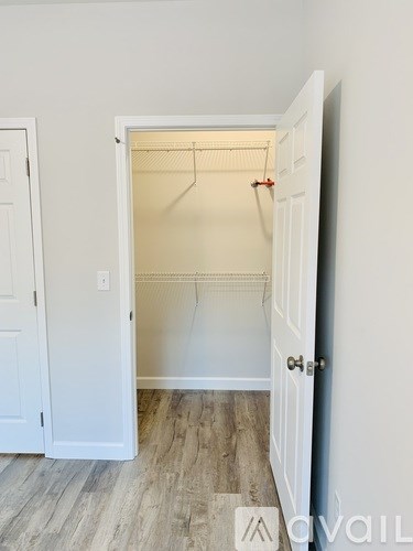 A white closet with a hanger and a door.
