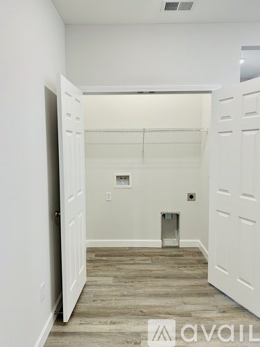 A hallway with a white door and a white wall.