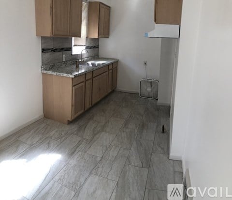 A kitchen with a marble countertop and wooden cabinets.