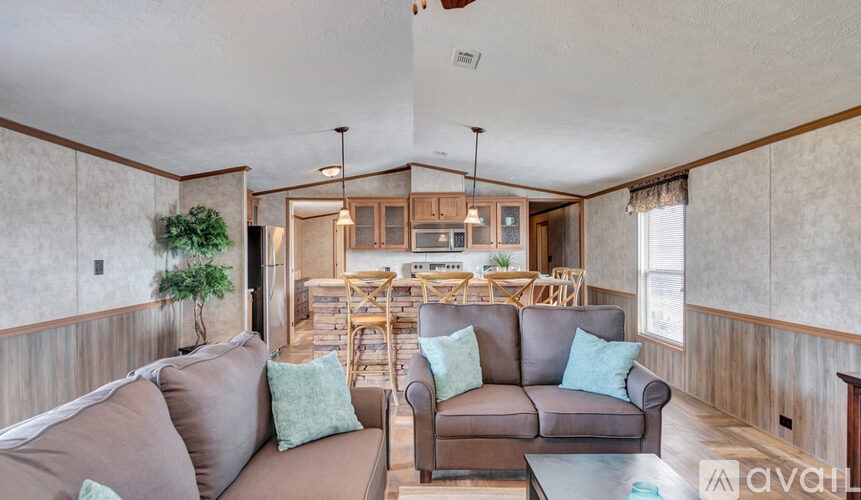 A living room with a couch, chairs, and a dining table.