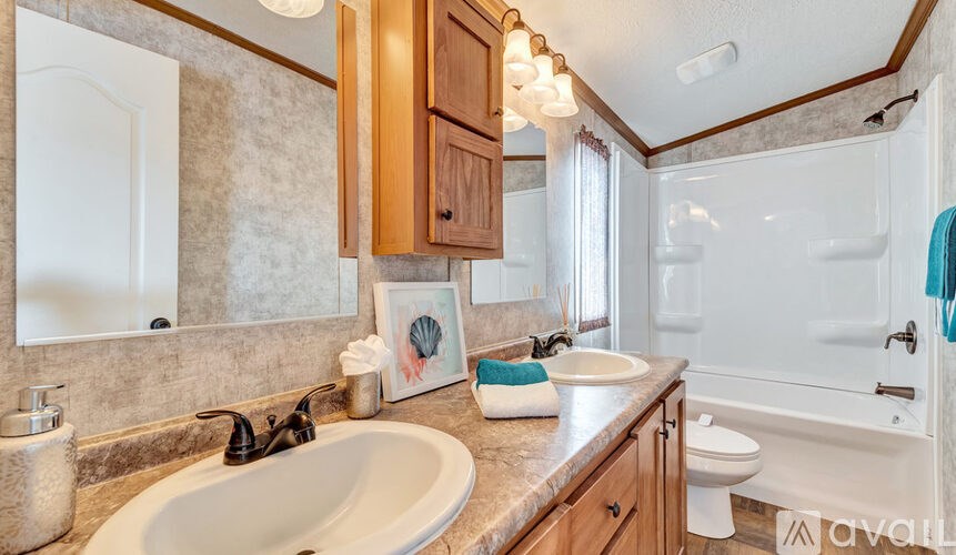 A bathroom with a sink, toilet, and bathtub.