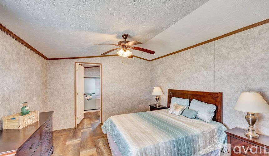 A bedroom with a bed, nightstand, and a ceiling fan.
