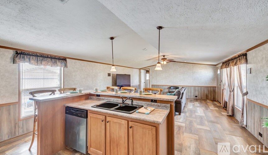 A kitchen with wooden cabinets and a central island with a sink.