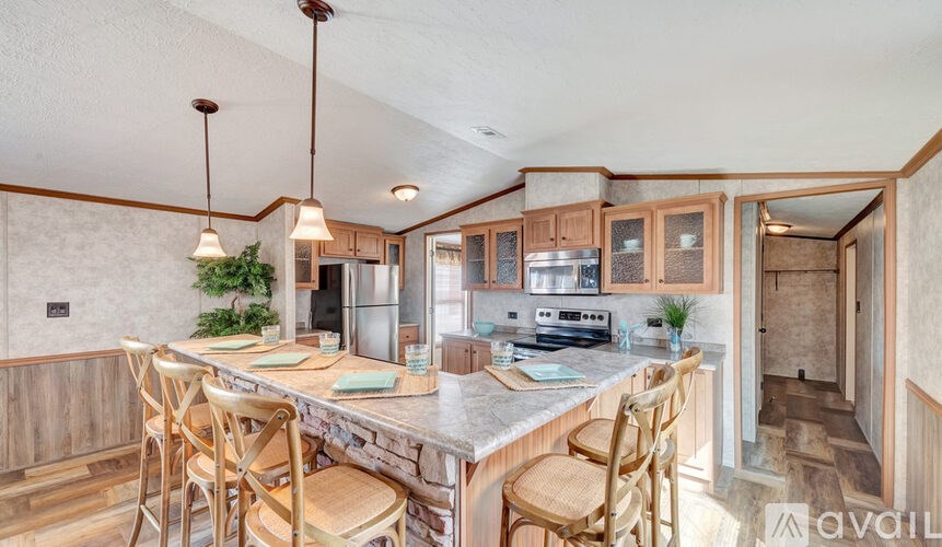 A kitchen with wooden chairs and a marble countertop.