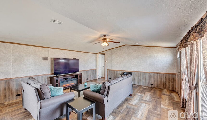 A living room with a television, couches, and a coffee table.