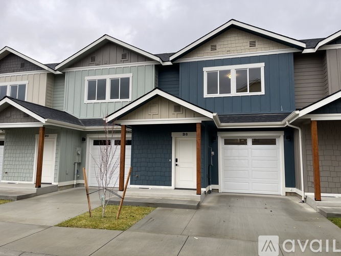 A row of houses with the first one being blue and the second one being grey.