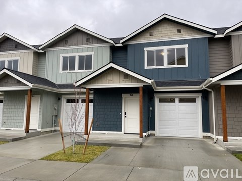 A row of houses with the first one being blue and the second one being grey.