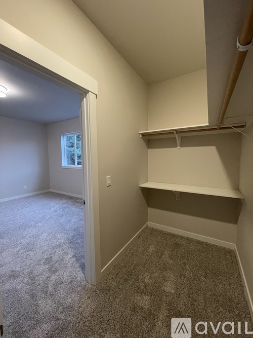 A room with a carpeted floor and a window.