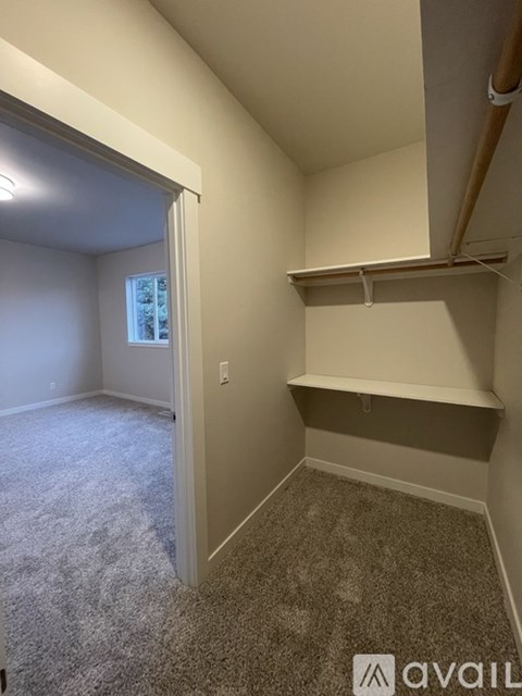 A room with a carpeted floor and a window.