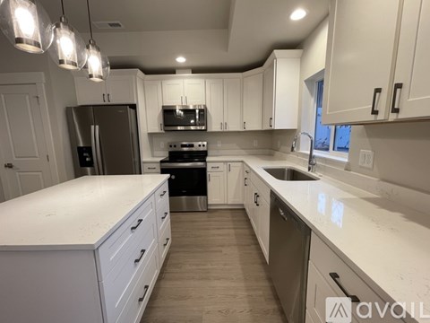A kitchen with white cabinets and a stainless steel refrigerator.