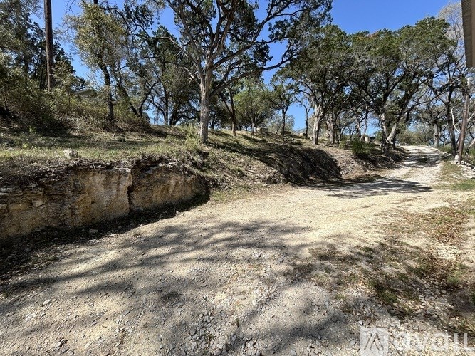 A dirt path winds through a wooded area.