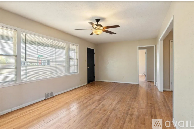 A room with a ceiling fan and wooden flooring.