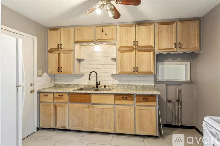 A kitchen with wooden cabinets and a white fridge.