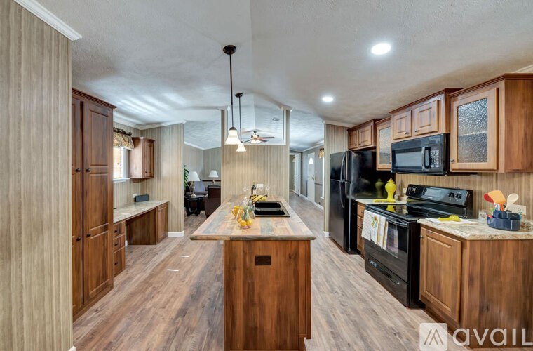 A kitchen with wooden cabinets and black appliances.