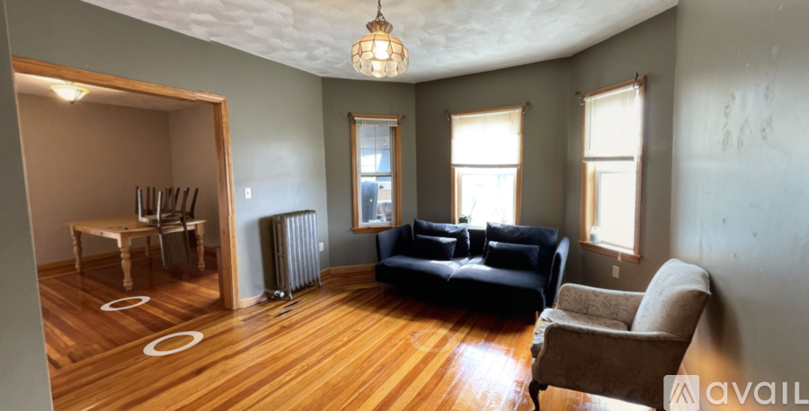 A living room with a black couch and a brown armchair.