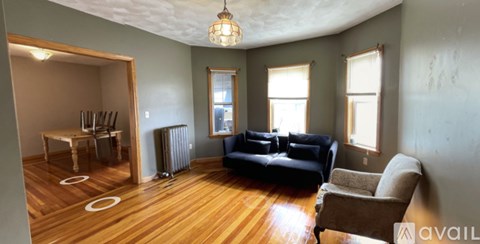 A living room with a black couch and a brown armchair.