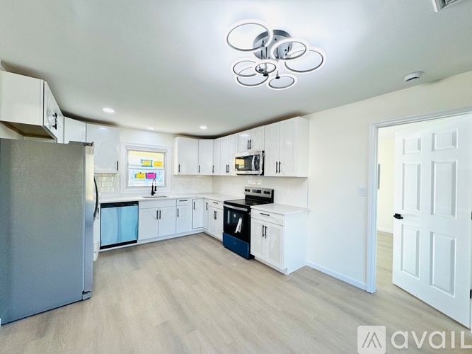 A modern kitchen with a refrigerator, microwave, oven, and cabinets.