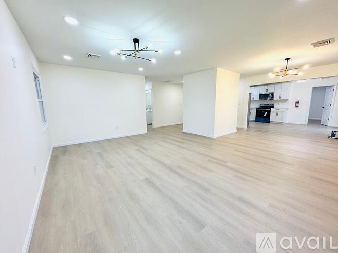 A spacious room with wooden flooring and a ceiling fan.
