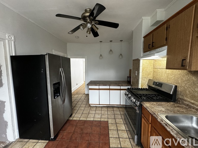 A kitchen with a black fridge and a black stove top oven.