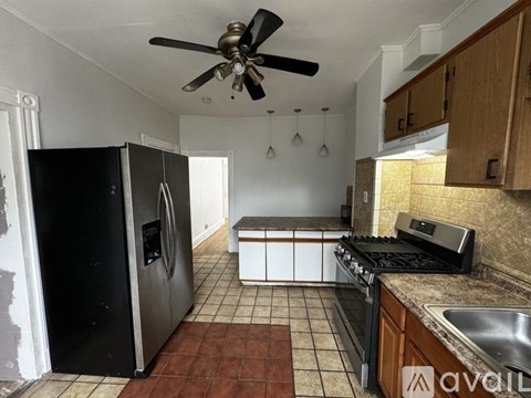 A kitchen with a black fridge and a black stove top oven.