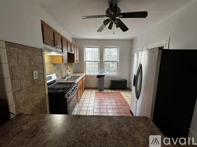 A kitchen with brown tiles and a fan.