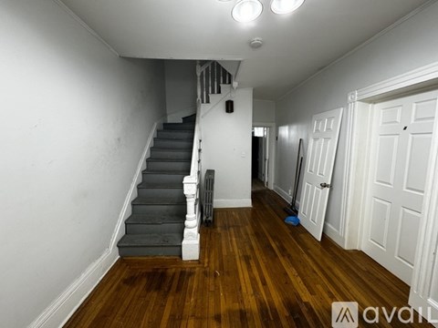 A room with a staircase and a broom.