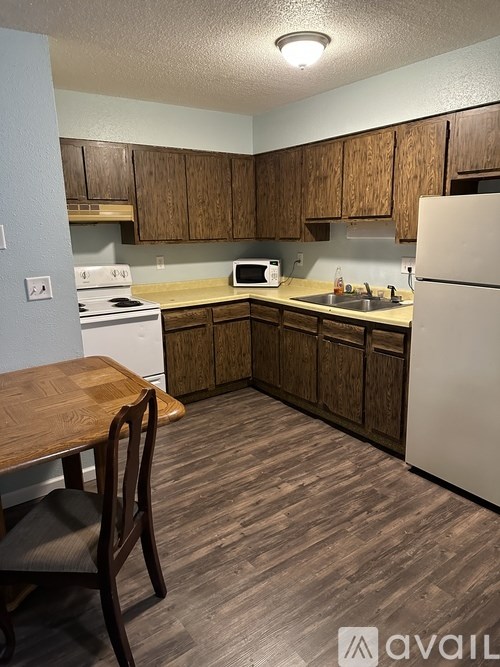 A kitchen with wooden cabinets and a white refrigerator.