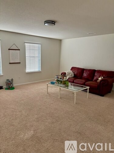 A living room with a red couch and a coffee table.