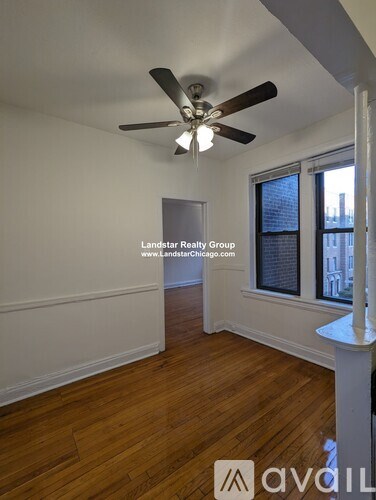 A room with a ceiling fan and wooden flooring.