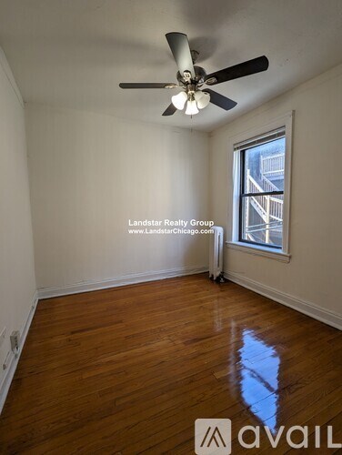 A room with a ceiling fan and wooden flooring.