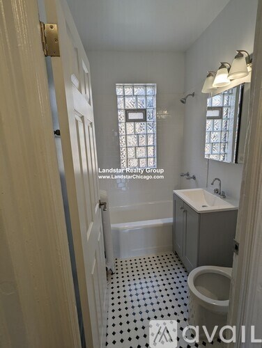 A white bathroom with a toilet, sink, and a window.
