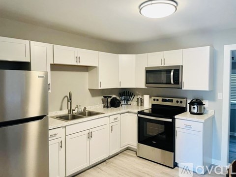 A kitchen with white cabinets and stainless steel appliances.