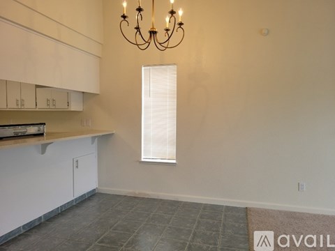 A kitchen with white cabinets and a chandelier.