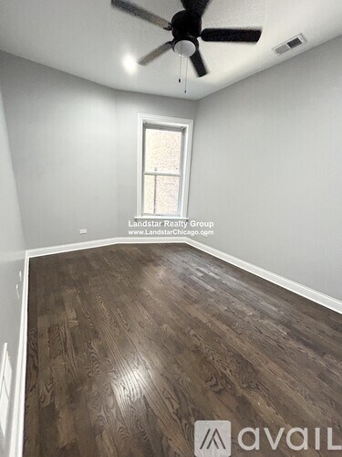 A room with a ceiling fan and wooden flooring.