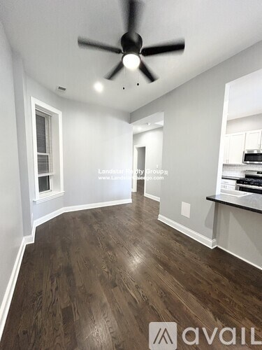 A room with a ceiling fan and wooden flooring.