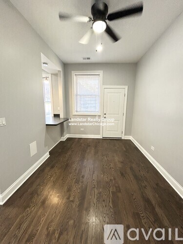 A room with a ceiling fan and wooden flooring.