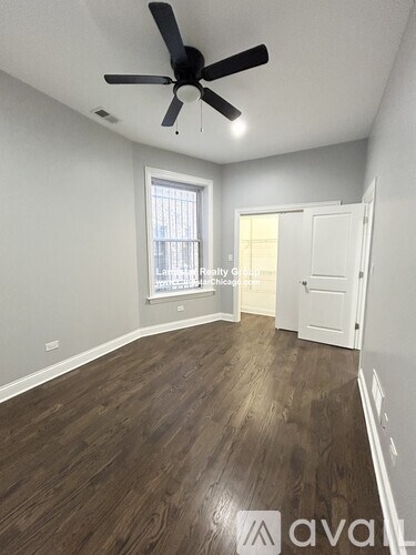 A room with a ceiling fan and wooden flooring.