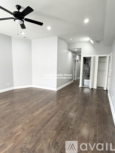 A room with a ceiling fan and wooden flooring.
